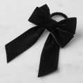 Detalle del servilletero de lazo de terciopelo negro con cintas largas sobre mármol - Negro