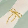 Rond de serviette doré en forme de nœud filaire sur une serviette en lin blanc - Doré