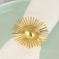 Golden sunburst napkin ring on white cloth placed on a minimalist green plate - Firework Style / Gold