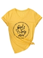 Dettaglio della maglietta con scollo a V color zenzero con stampa Girl's Trip 2026 e nodo - S / Giallo (Testo Nero)