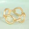 Detalle de un servilletero geométrico de metal dorado mate que muestra el diseño de eslabones huecos - Dorado Mate