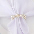 Elegant white pearl and gold wire woven napkin ring on a white fabric napkin decoration - Pearl Bracelet Style Napkin Ring