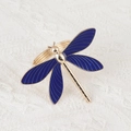 Detailed view of blue enamel dragonfly napkin ring with golden metal on lace background - Dragonfly Design / Blue