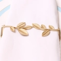 Close-up of matte gold leaf napkin ring with intricate vein details on a white cloth - Leaf Frame Napkin Ring