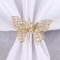 Gros plan du rond de serviette papillon doré avec ailes ajourées en métal poli - Style Maille Creuse