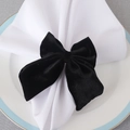 Elegant black velvet bow napkin ring set on a white ceramic plate for table decor - Black