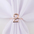 Detail of rose gold number 2 napkin ring on white fabric for party table setting decor - Number 2 / Rose Gold