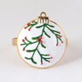 Detail eines Serviettenrings mit Mistelblättern und roten Beeren auf Goldmetall - Weihnachtsschneeball (Weißer Mistelzweig)