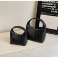 Detail view of two minimalist black matte leather handbags with double zippers and top handles - Large / Black