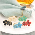 Elegantes servilleteros florales en seis colores con acabado dorado y esmalte - Blanco Roto Verde Menta Cian Profundo Negro Azul Claro Rojo