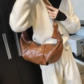 Braune gefaltete Croissant-Tasche aus glänzendem PU-Leder mit geknotetem Schultergurt - Braun