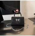 Detail einer schwarzen Paillettenhandtasche mit silberner Schleife und Kettenriemen - Schwarz