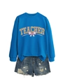 Detail of bright blue teacher sweatshirt with clover pattern and pink bow graphics - Lake Blue