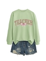 Dettaglio della felpa verde teacher con grafica trifoglio fiocco e pantaloncini di jeans - S / verde oliva