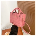 Dettaglio della borsa in pelle PU rosa trapuntata con logo dorato e manici - Rosa