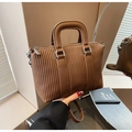 Primo piano della borsa tote marrone con trama goffrata verticale e dettagli argentati - Marrone