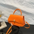 Schicke orangefarbene Leder-Handtasche mit gewölbtem Boden und Metallschnalle - Orange