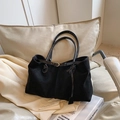 Minimalistische schwarze matte Tragetasche aus Wildlederimitat auf weißem Sofa - Schwarz