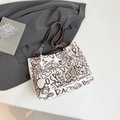 Schicke cremefarbene Canvas-Tasche mit Graffiti-Print und Leder-Kettengriffen in Flachlage - Ohne Anhänger / Braun