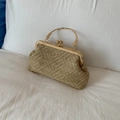 Close-up of golden woven evening bag with metallic handle and retro sphere clasp - Khaki