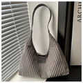 Detail of grey corduroy hobo bag showing vertical texture and leather fashion label - Gray