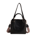 Fashionable black bucket handbag with woven wide strap and golden hardware in sleek leather - Black