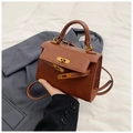 Detailed close-up of brown leather handbag with gold hardware lock and strap - Brown / 19.5cm x 14cm x 8cm