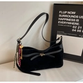 Detail einer schwarzen Wildleder-Schultertasche mit goldener Hardware und Schleife - Schwarz