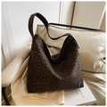 Detailed view of leopard print tote bag with soft fabric texture on a white chair - Leopard Coffee
