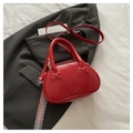 Red leather handbag with bow embossed details and white lace ribbon on grey blazer - Red