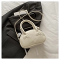 Chic cream white pod-shaped handbag with cute bow accents and a round handle - White