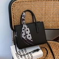 Black pebbled leather tote bag with heart-patterned silk scarf and crossbody strap - Black
