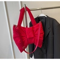 Detail of red bow-shaped nylon tote bag featuring detachable wide strap and metallic clips - Red