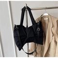 Detail of black nylon tote bag with large bow design and adjustable strap on a coat - Black