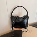 Glossy black patent leather handbag with pleated texture and adjustable shoulder strap - Black
