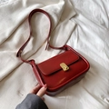 Vintage dark red crossbody bag with golden oval buckle and sleek faux leather finish - Red