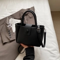 Bolso tipo cubo de cuero granulado negro con asa superior y correa ajustable - Negro