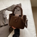 Bolso de mano marrón con textura litchi, correa bandolera y hebilla circular - Marrón