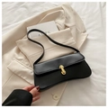 Minimalist black baguette shoulder bag in matte leather featuring a gold buckle clasp - Black