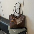 Brown woven leather tote bag with gold charm on a book background for business style - Coffee (With Bell Rope Charm)
