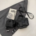 Sac seau tissé noir avec bandoulière et pochette à cordon sur un blazer gris - Noir
