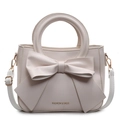Chic cream faux leather bucket bag featuring a large bow and gold fashion lettering - Off White