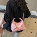 Rosafarbene Retro-Henkeltasche mit Steppmuster und runden Metallgriffen an einem Model - Rosa