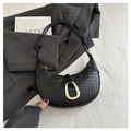 Detalle de bolso medialuna trenzado negro con hebilla dorada y asa con nudos decorativos - Negro