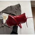 Détail du sac à bandoulière en cuir verni rouge avec nœud chic et rivets argentés - Bordeaux