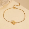 Detailweergave van de holle zonnehanger aan een verfijnde gouden roestvrijstalen armband - Gouden Zon Hanger Stijl (C5937)