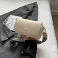 Cremefarbene Zylindertasche aus strukturiertem Leder mit geometrischem Gurt - Gebrochenes Weiß