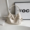 White bucket bag with lychee texture featuring stylish bow ribbons and front zipper pockets - White