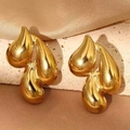 Detailed shot of gold triple teardrop earrings on a stone base with silk fabric decor - Golden Fluid Water Drop Style (F2109)