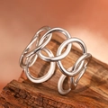 Modern hollow silver interlocking ring with minimalist open design on dark wood - Silver Style (C4856)